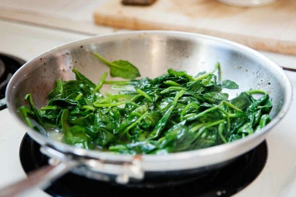 How to Make a Quinoa Bowl - Wilted Spinach in skillet