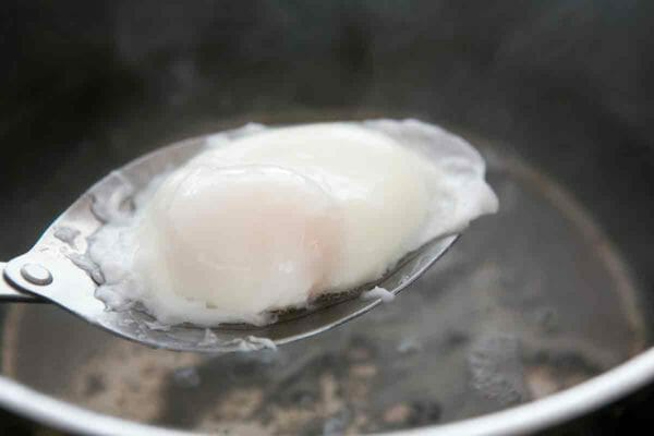 removed poached egg with a slotted spoon