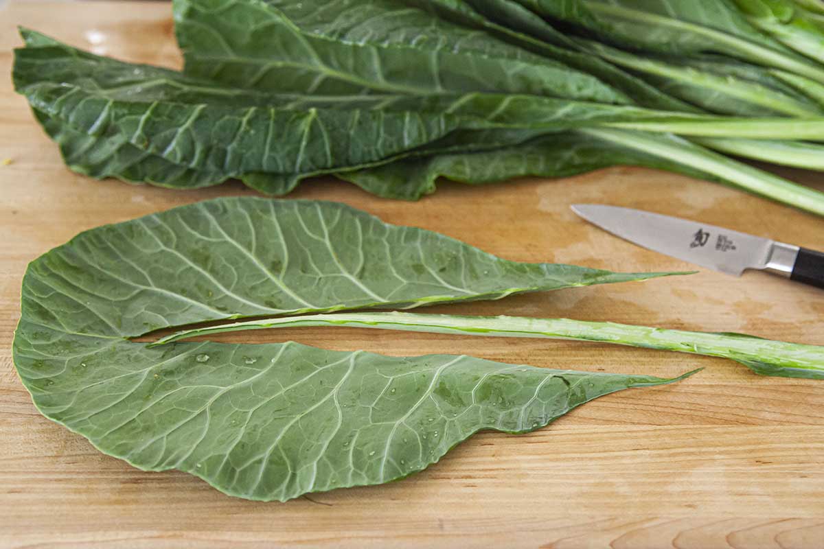 Prepare collard greens by trimming out the stem