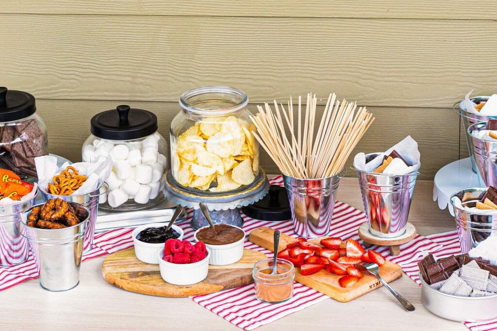 Table covered in ingredients for a backyard smores party.