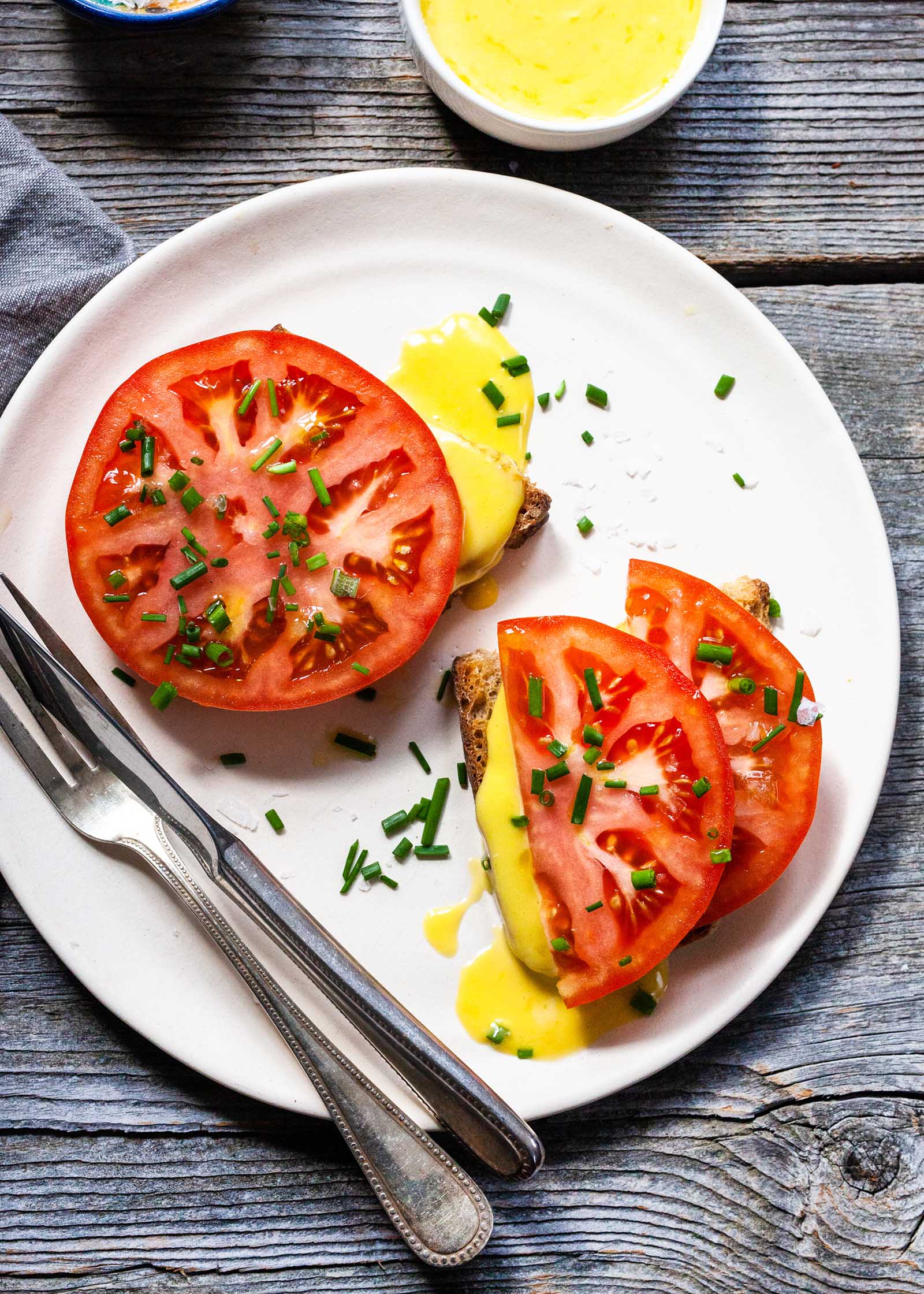 Aioli sauce drizzled over toasted tomato sandwich along with chopped chives.