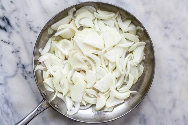 Sliced onions in a skillet to make a focaccia recipe.