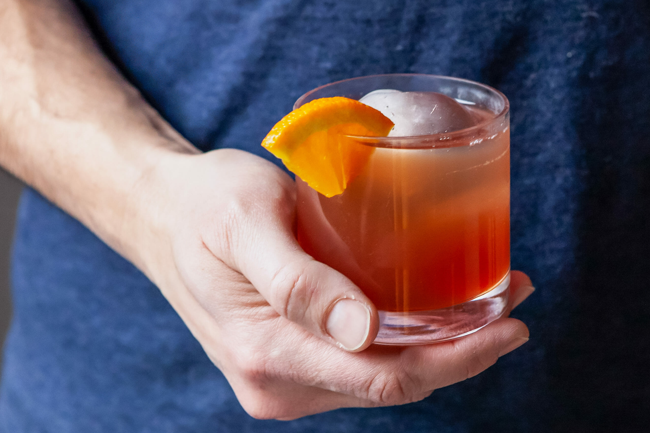A person holding an Alcohol free negroni.